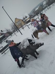 Uśmiechnięte Julka Natalia i Zuzia podziwiające uroki zimy w towarzystwie figur leśnych zwierząt