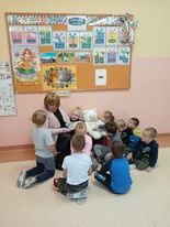 dzieci wraz z misiem słuchają misiowej opowieści.