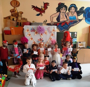 Dzieci stoją i siedzą w trzech rzędach; w rękach trzymają kartki walentynkowe