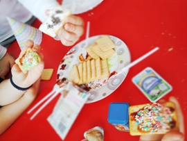 Uczniowie prezentują swoje kanapki wykonane z dżemu i serka, nasion chia. Krakersy są na talerzu.